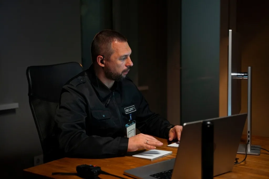 Corporate security officer conducting digital investigation at desk with multiple computers
