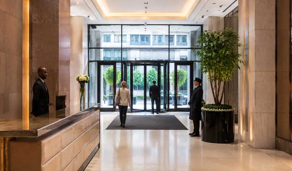 Doorman and concierge providing security at the entrance of a luxury Manhattan residential tower.
