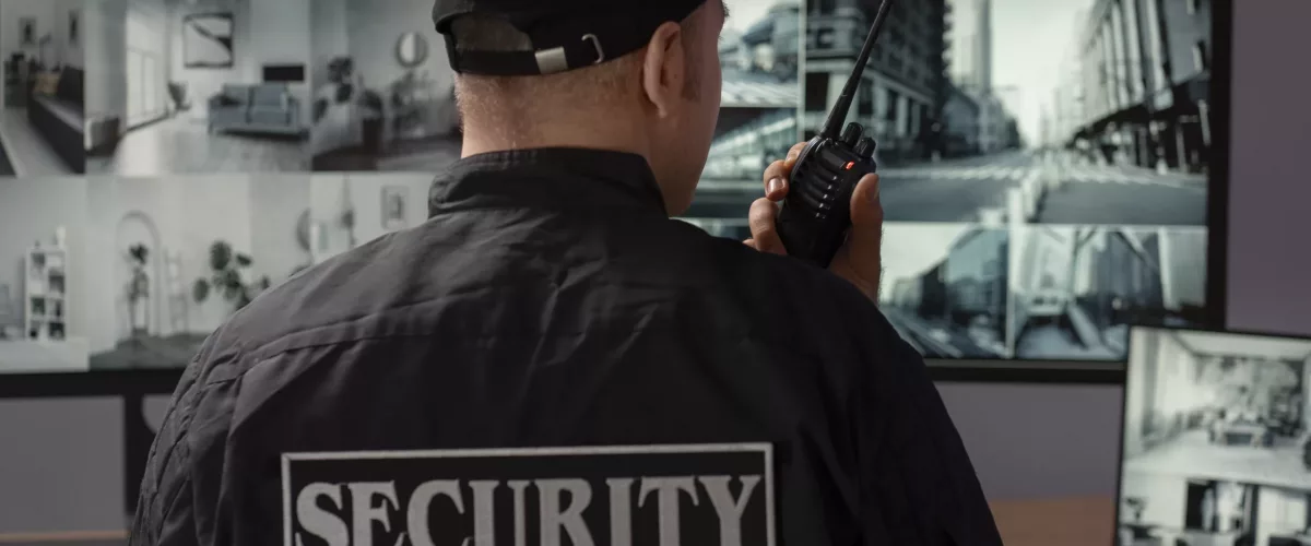 portrait-male-security-guard-with-radio-station-camera-screens